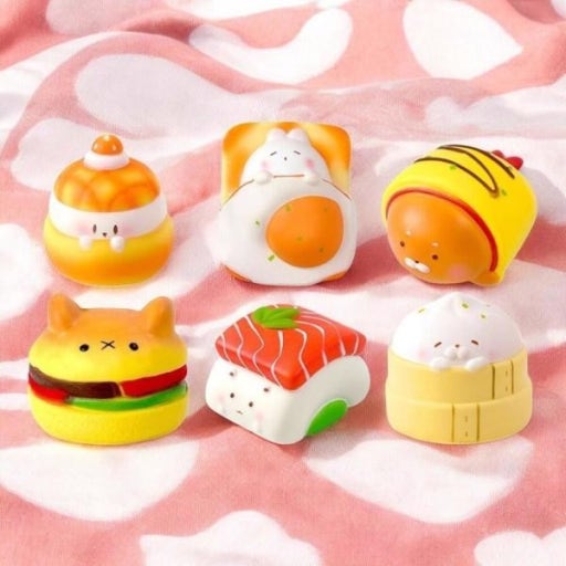 Set of cute, cartoon-like food-shaped items on a pink blanket with cloud pattern