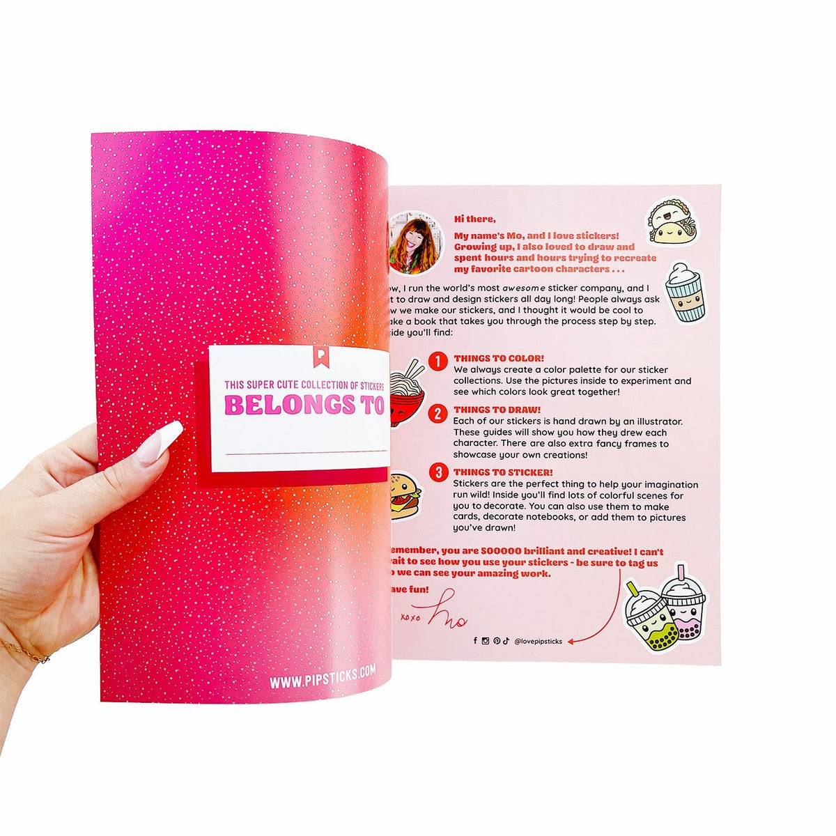 Hand holding a pink sticker book with open pages showing content.