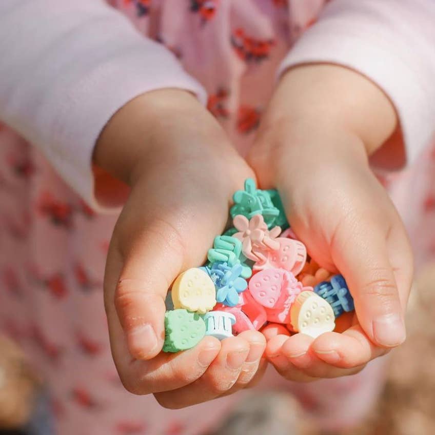 Child's hands holding colorful candy-shaped toys
