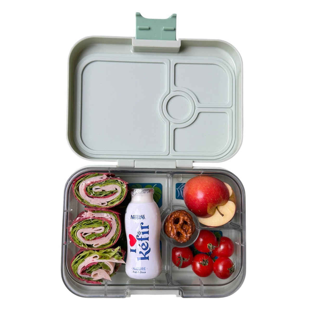Open lunchbox with compartments containing sandwiches, a bottle, fruits, and vegetables on a white background.