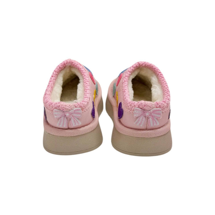 A pair of pink slip-on slippers with a soft cream fleece lining, decorated with embroidered bows and colorful floral details, shown from the back on a white background.