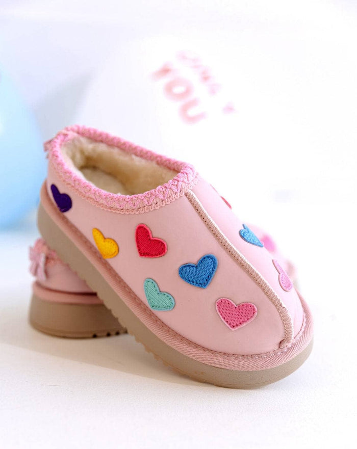 A pair of pink children's slip-on shoes decorated with colorful embroidered hearts in pink, blue, red, yellow, and purple, shown on a light background.