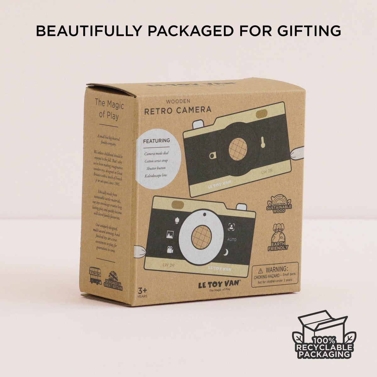 Cardboard box packaging of a wooden retro camera toy by Le Toy Van on a light pink background.