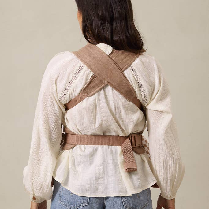 Person wearing a beige back brace against a neutral background