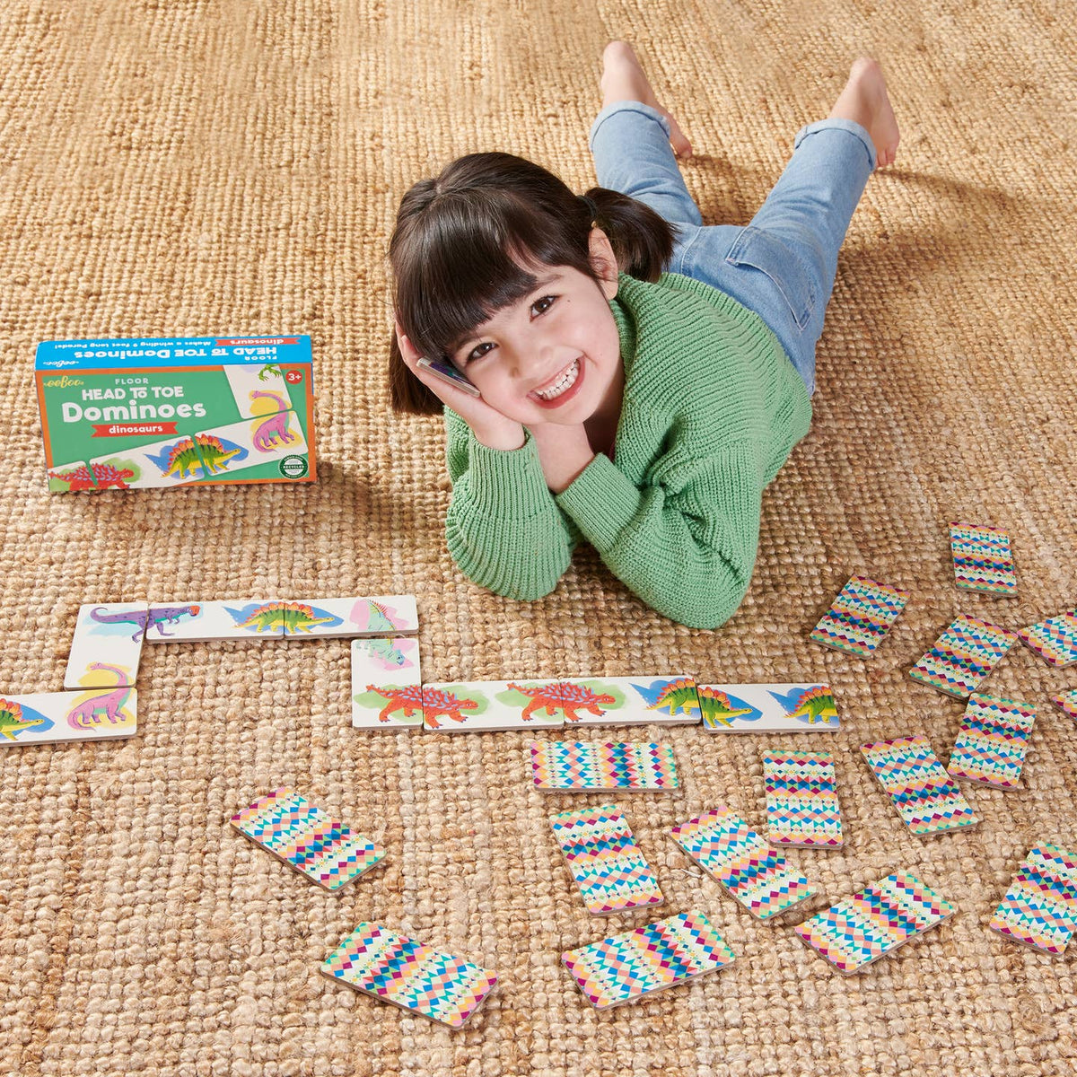 Child playing with dominoes on a woven surface