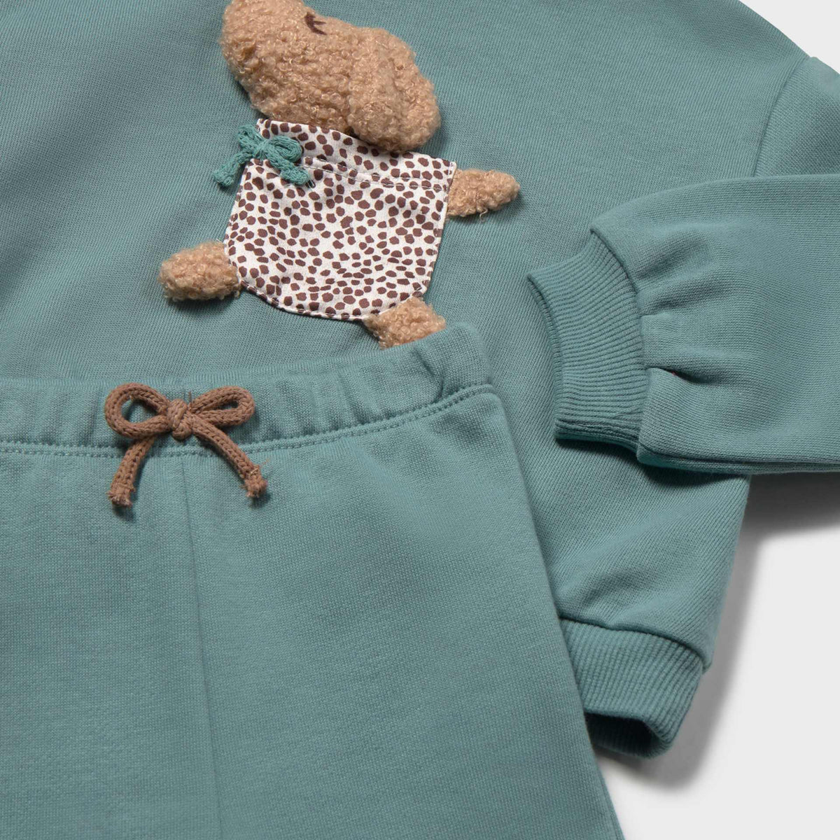 Teal children's outfit with teddy bear plush toy on a white background