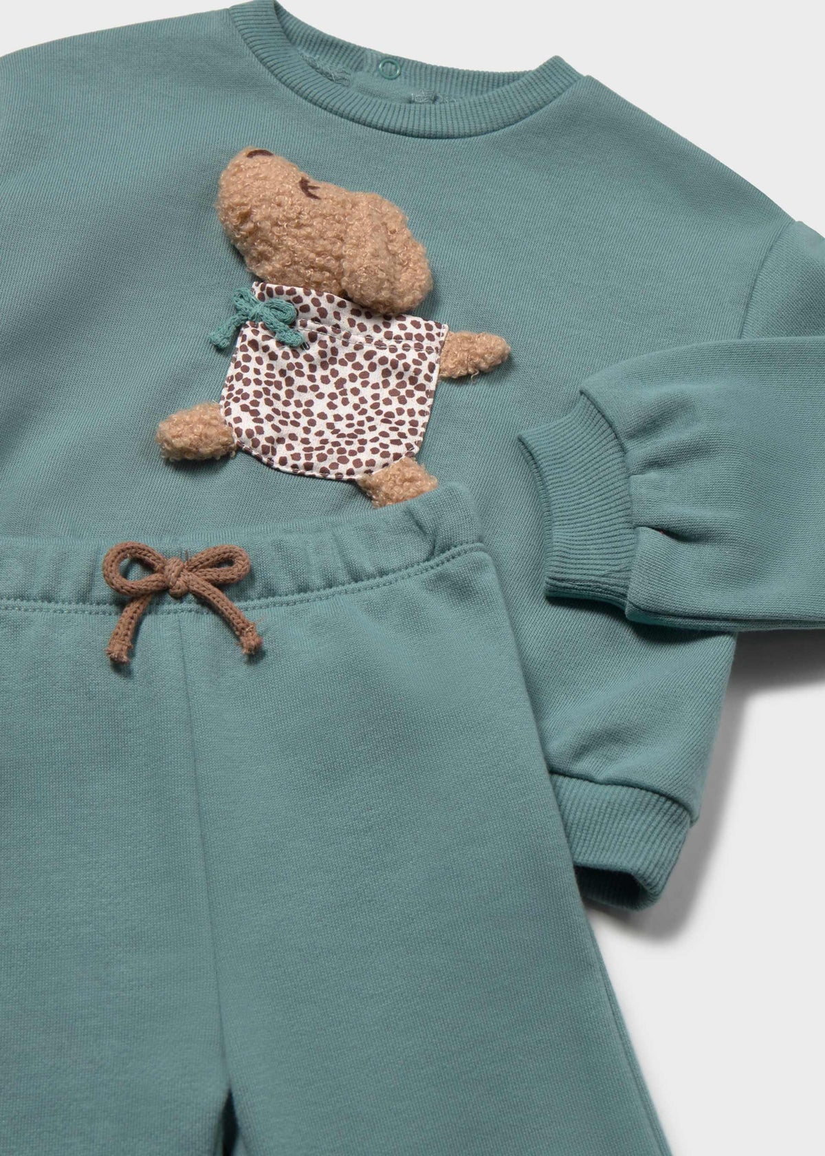 Teal children's outfit with teddy bear plush toy on a white background