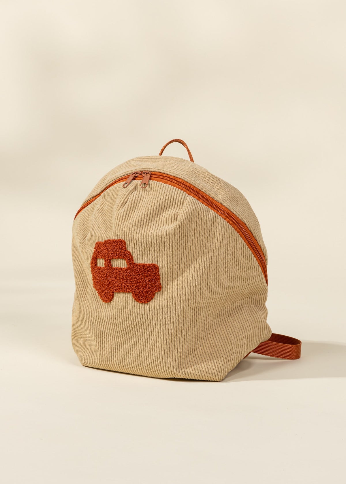 Beige backpack with orange truck design on a beige background