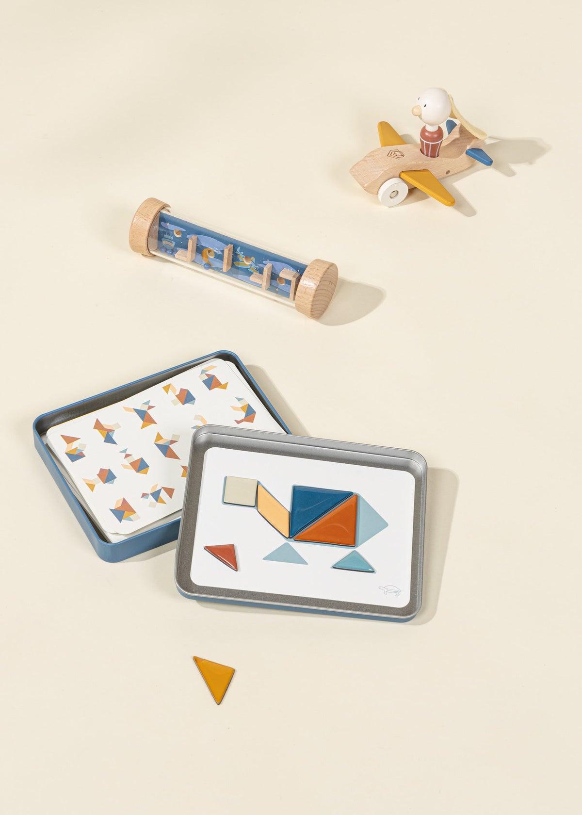 Set of geometric shape cards with a wooden airplane and cylindrical toy on a beige background