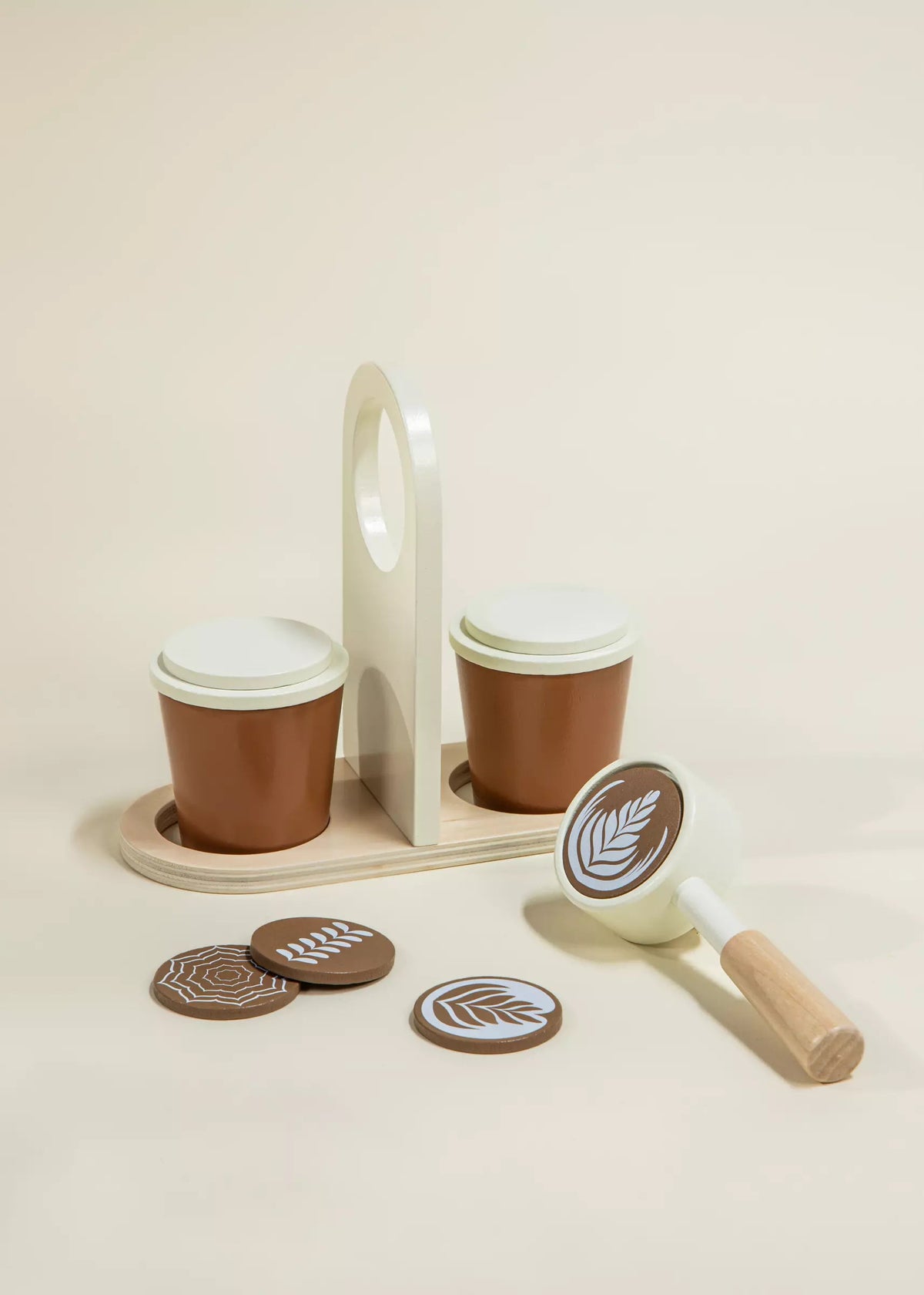 Wooden toy coffee set with cups, a tray, and a scoop on a beige background