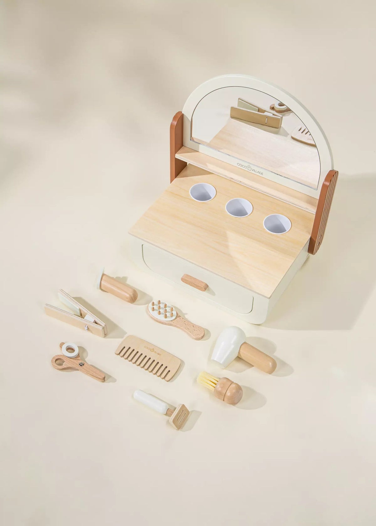 Wooden toy vanity set with mirror and various utensils on a beige background