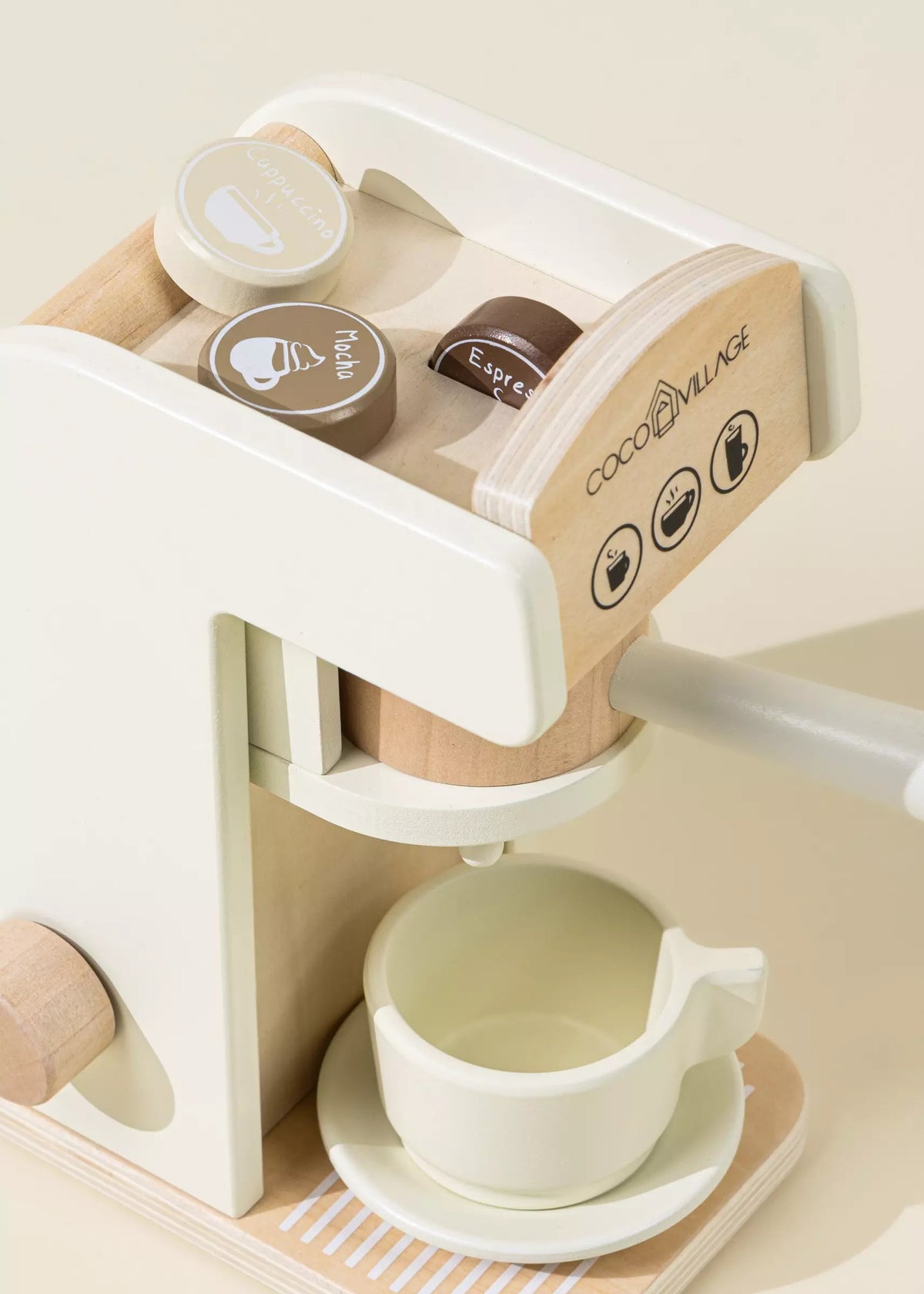 Children's toy coffee maker with a cup and saucer on a light beige background