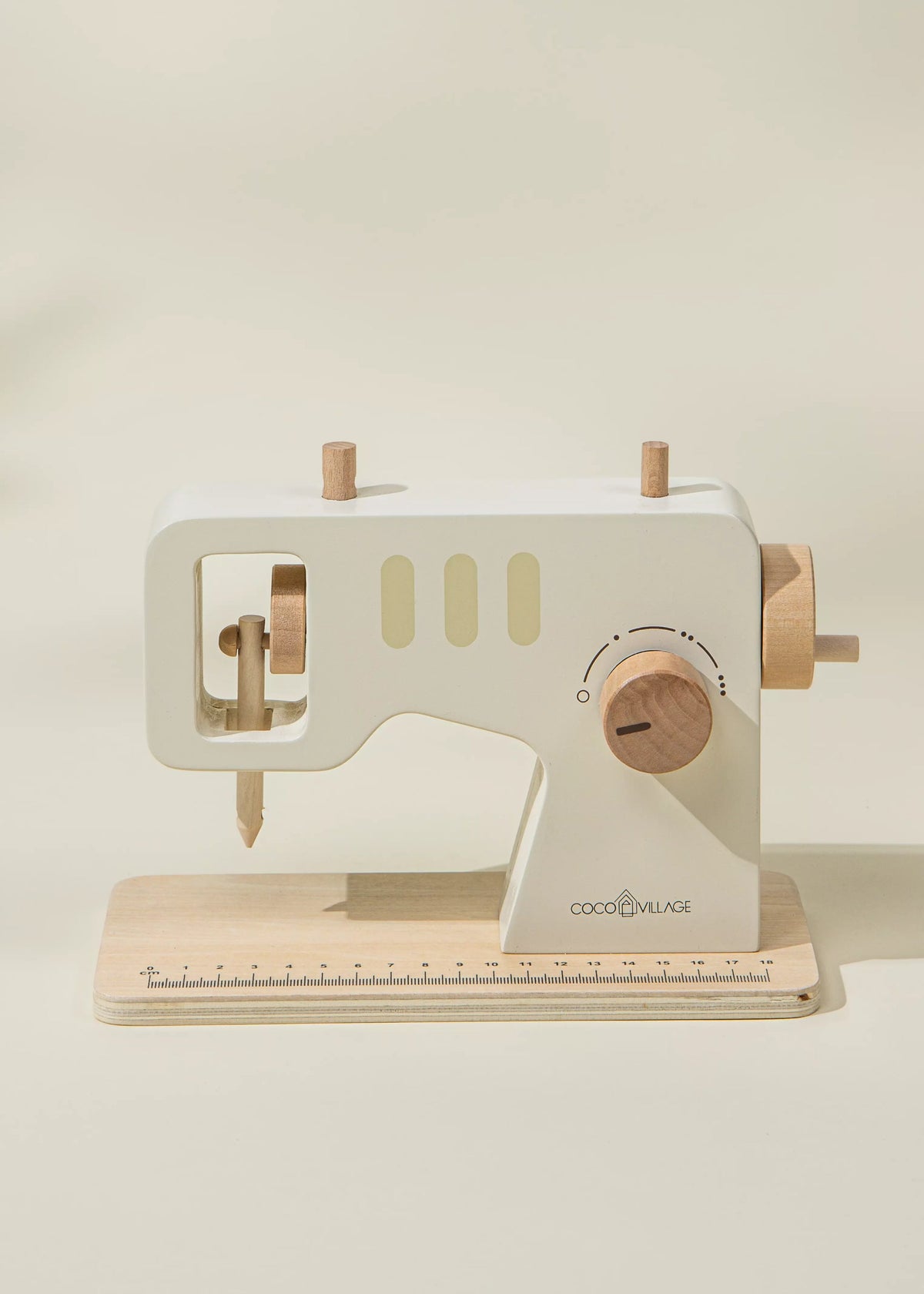 Wooden toy sewing machine with a beige background