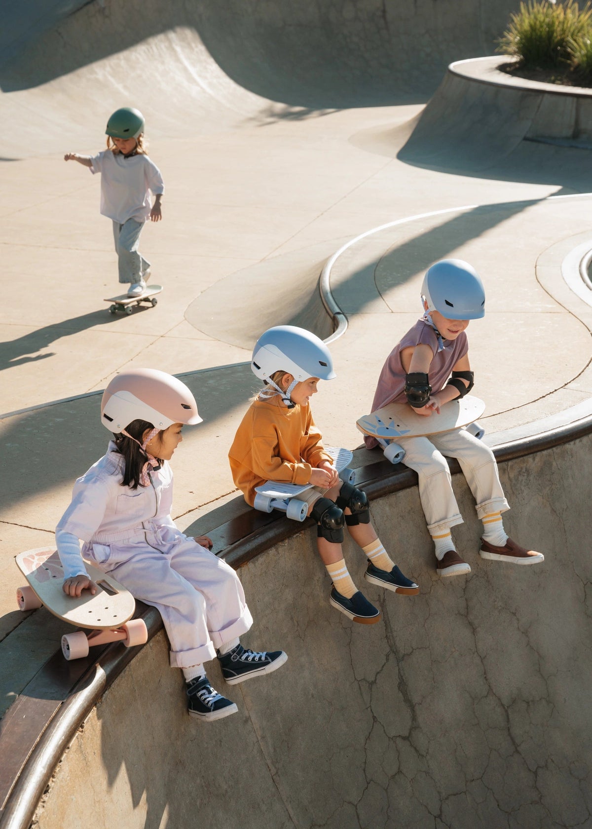 Children with skateboards and helmets at a skate park