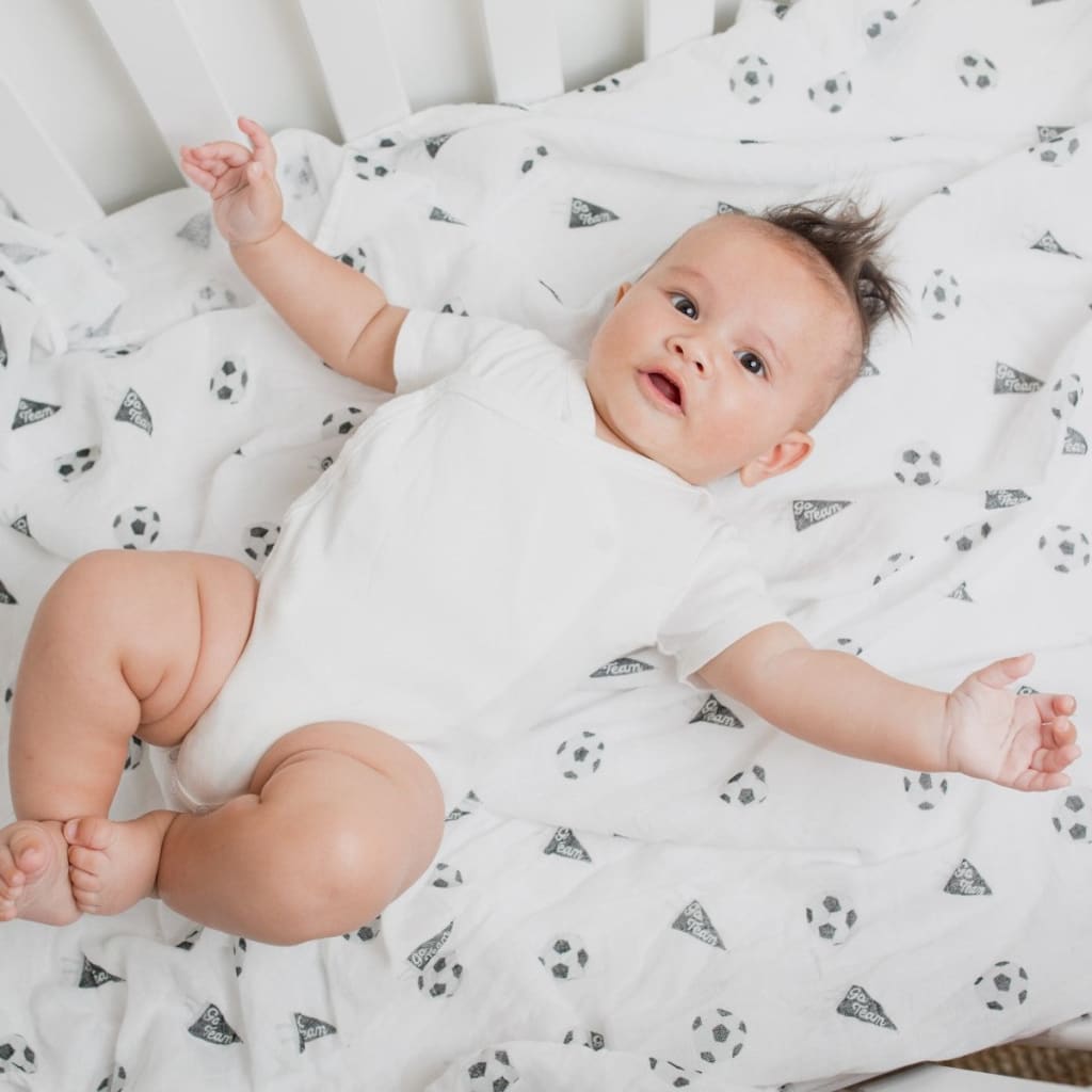 Baby lying on a white blanket with black patterns