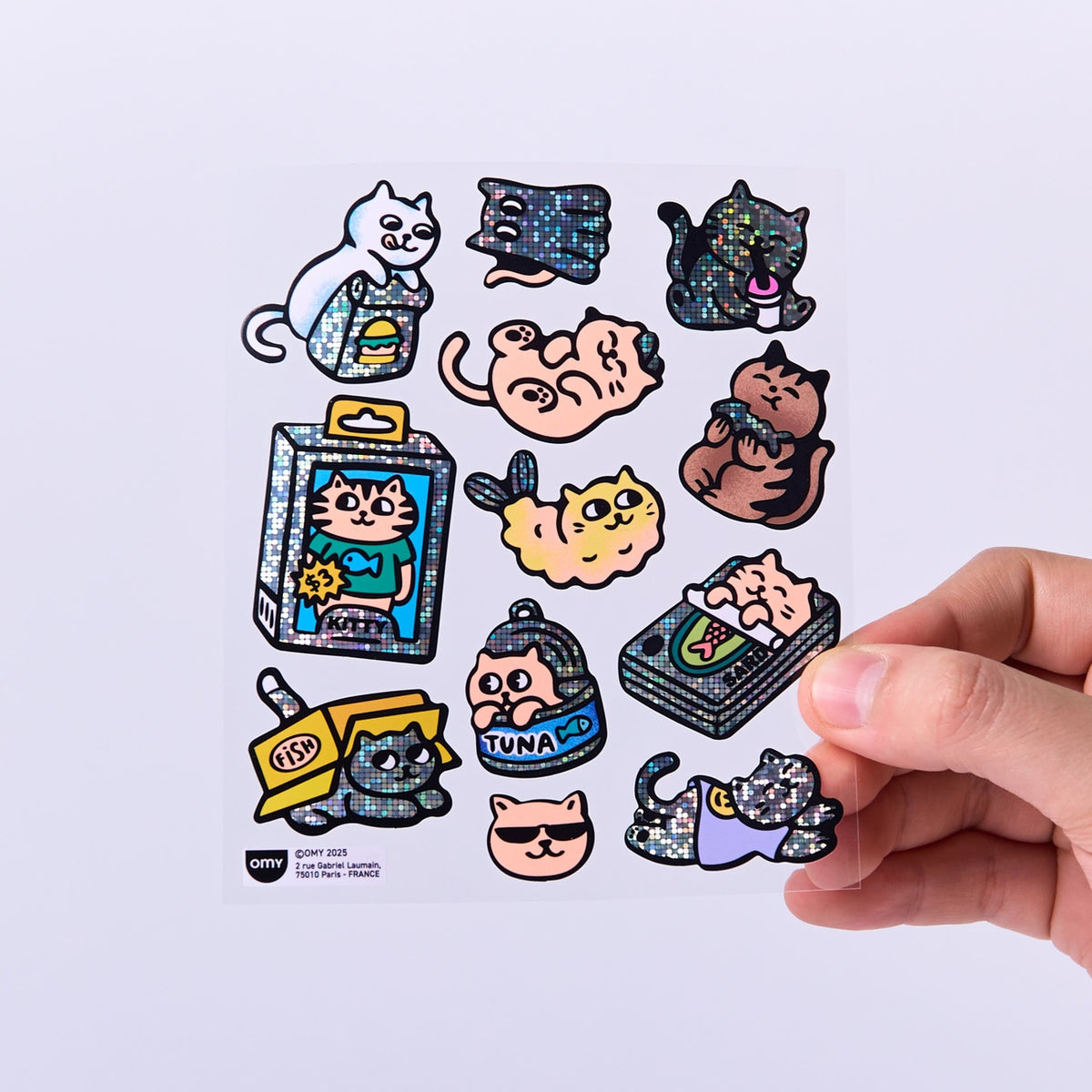 Collection of cat-themed stickers on a white background with a hand holding one sticker.