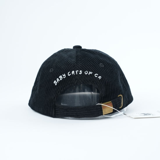 Black cap with 'BABY CATS OF CA' text on a white background