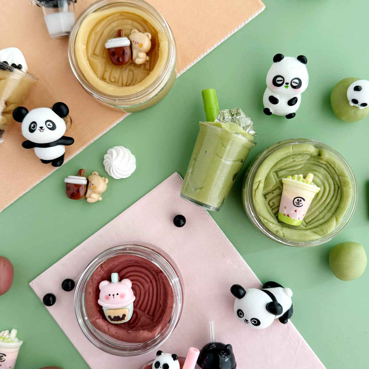 Various desserts and drinks with panda-themed figurines on a colorful background