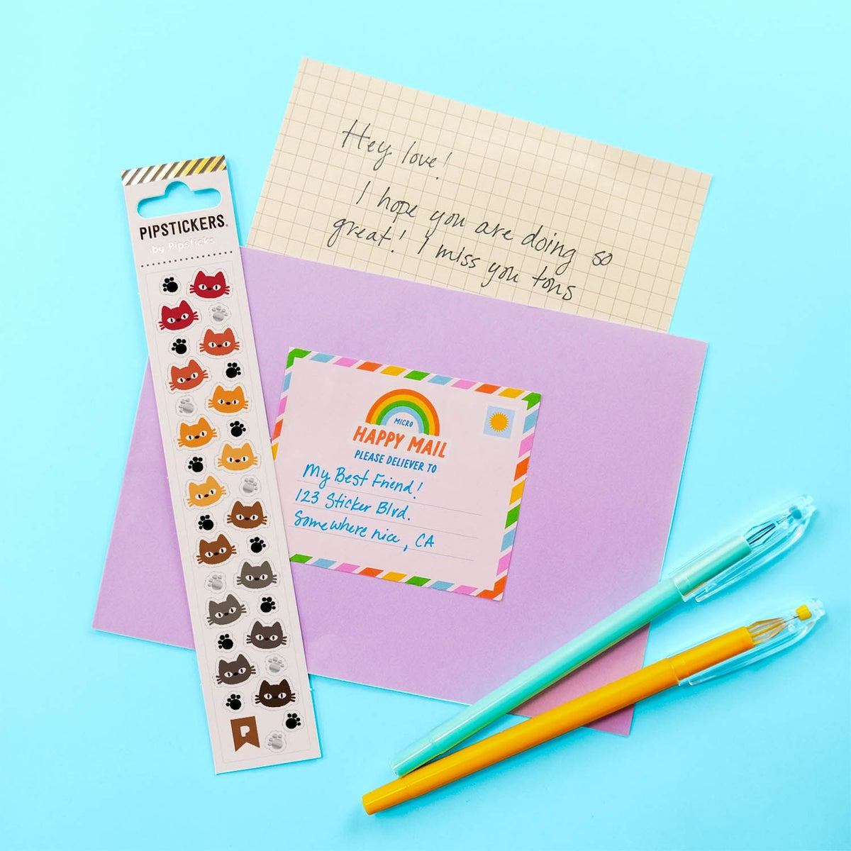 Stationery items including a sticker sheet, notebook, and pens on a colorful background.