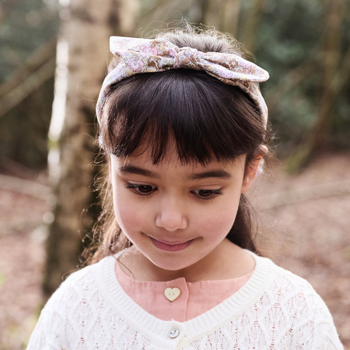 Young girl wearing a headband with a floral pattern outdoors