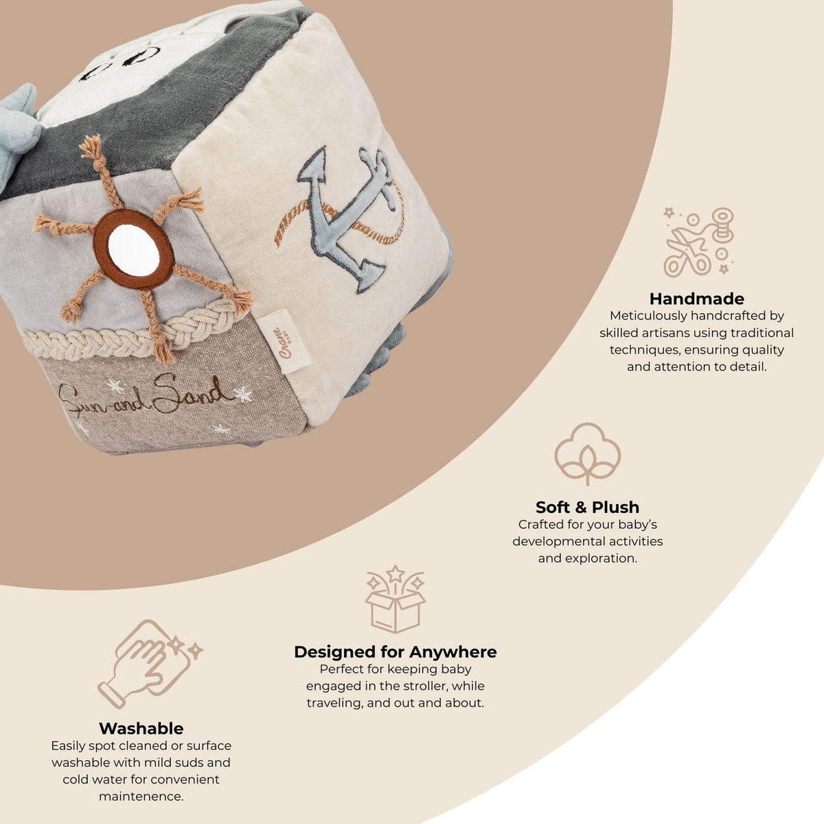 A handmade baby activity cube toy with embroidered details, shown on a beige background with descriptive text callouts highlighting its handcrafted quality, soft plush texture, washability, and versatility.