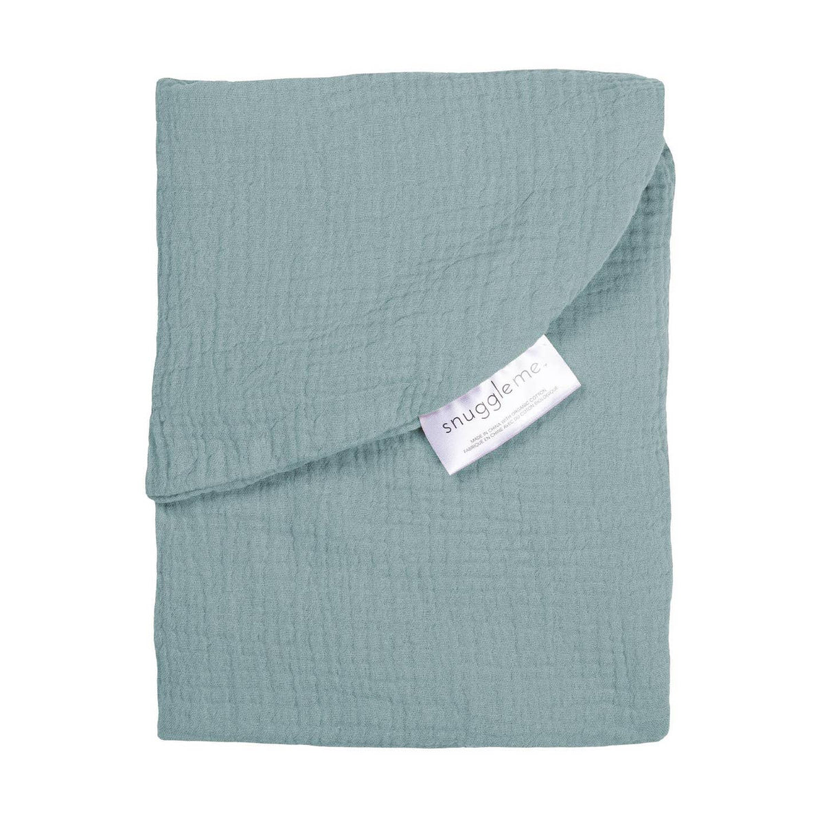 A folded dusty blue muslin blanket with a textured crinkle fabric, featuring a white 'snugglerme' brand tag, set against a plain white background.