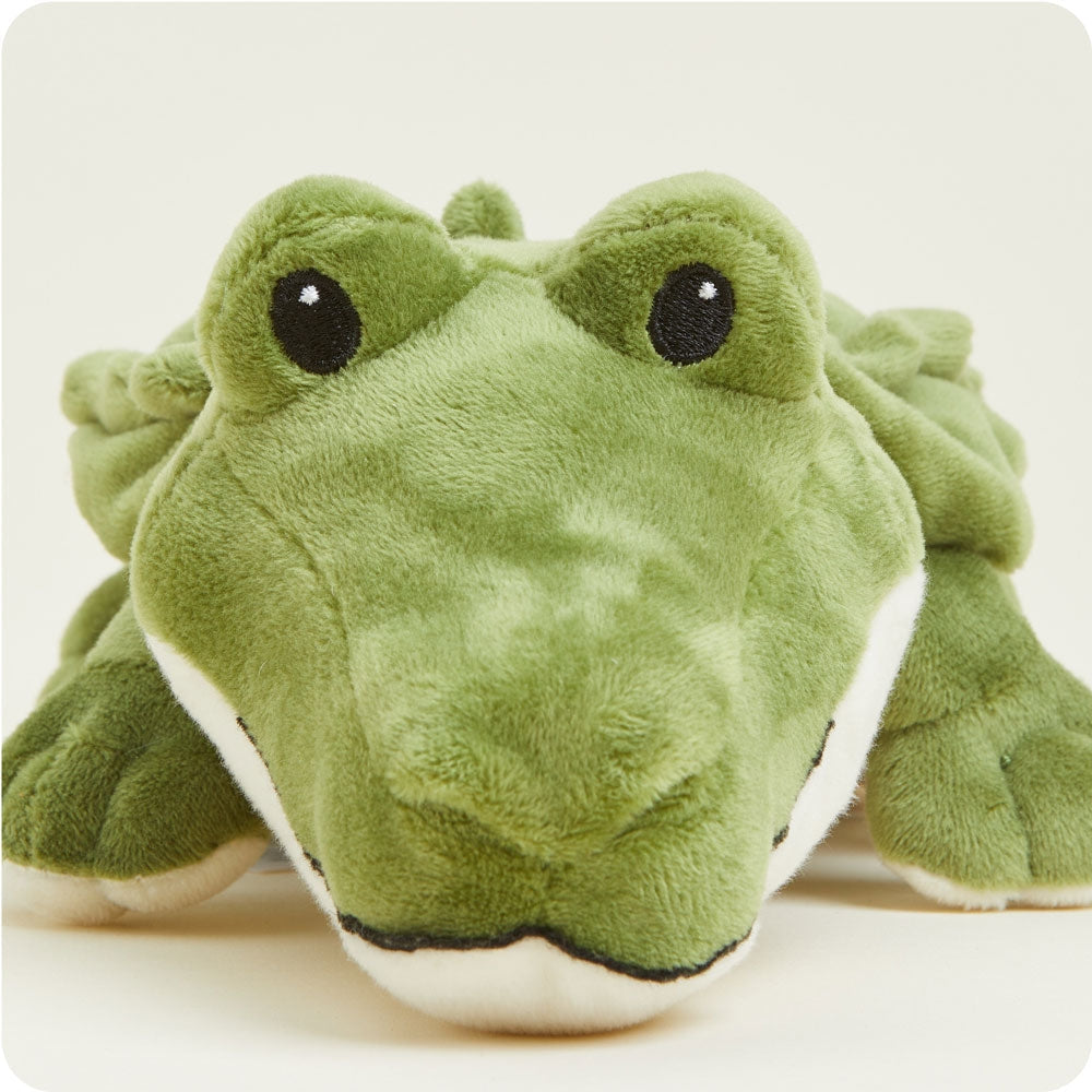 Green plush toy resembling a crocodile on a white background