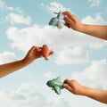 Two pairs of hands reaching out towards each other with a blue sky and white clouds in the background.