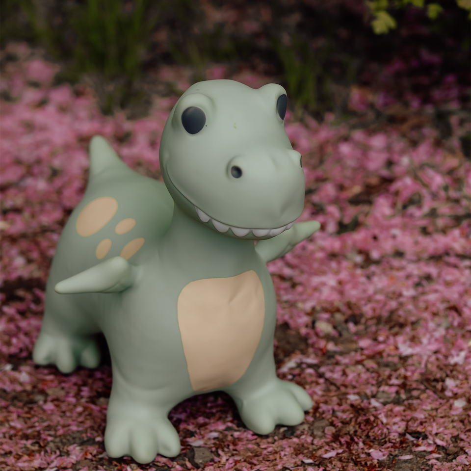 Toy dinosaur figure on a ground covered with pink petals
