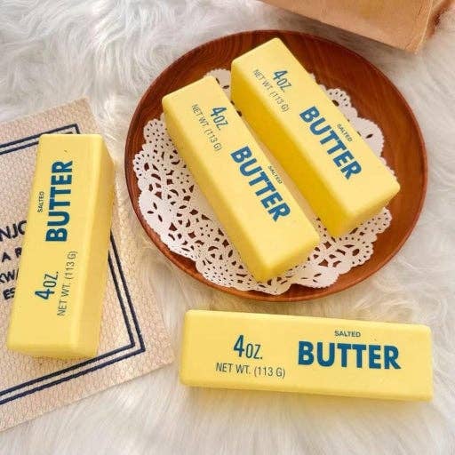 Yellow butter bars with 'Butter' text on a wooden plate and doily