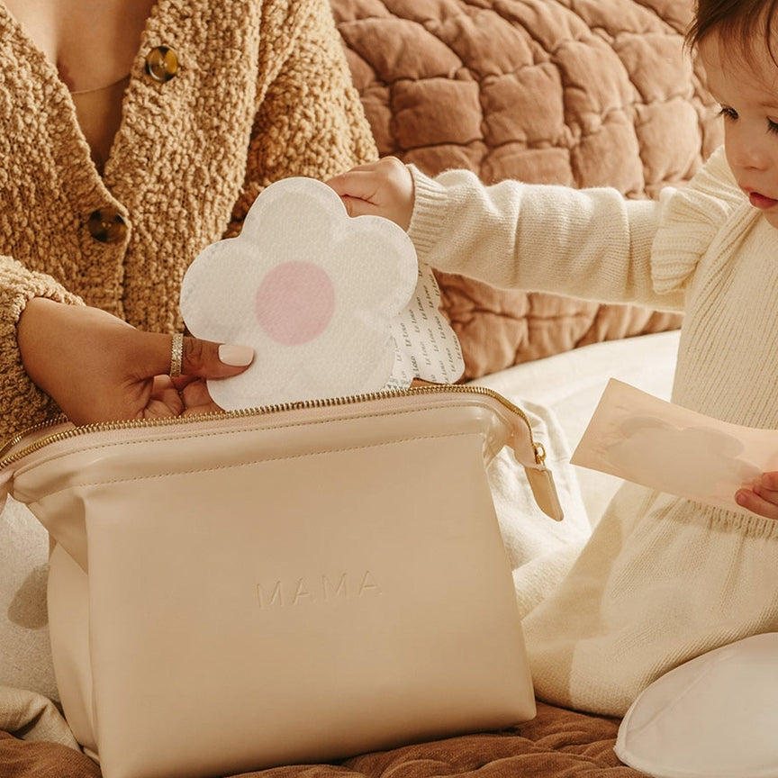 Woman and child interacting with a cloud-shaped pouch on a textured surface