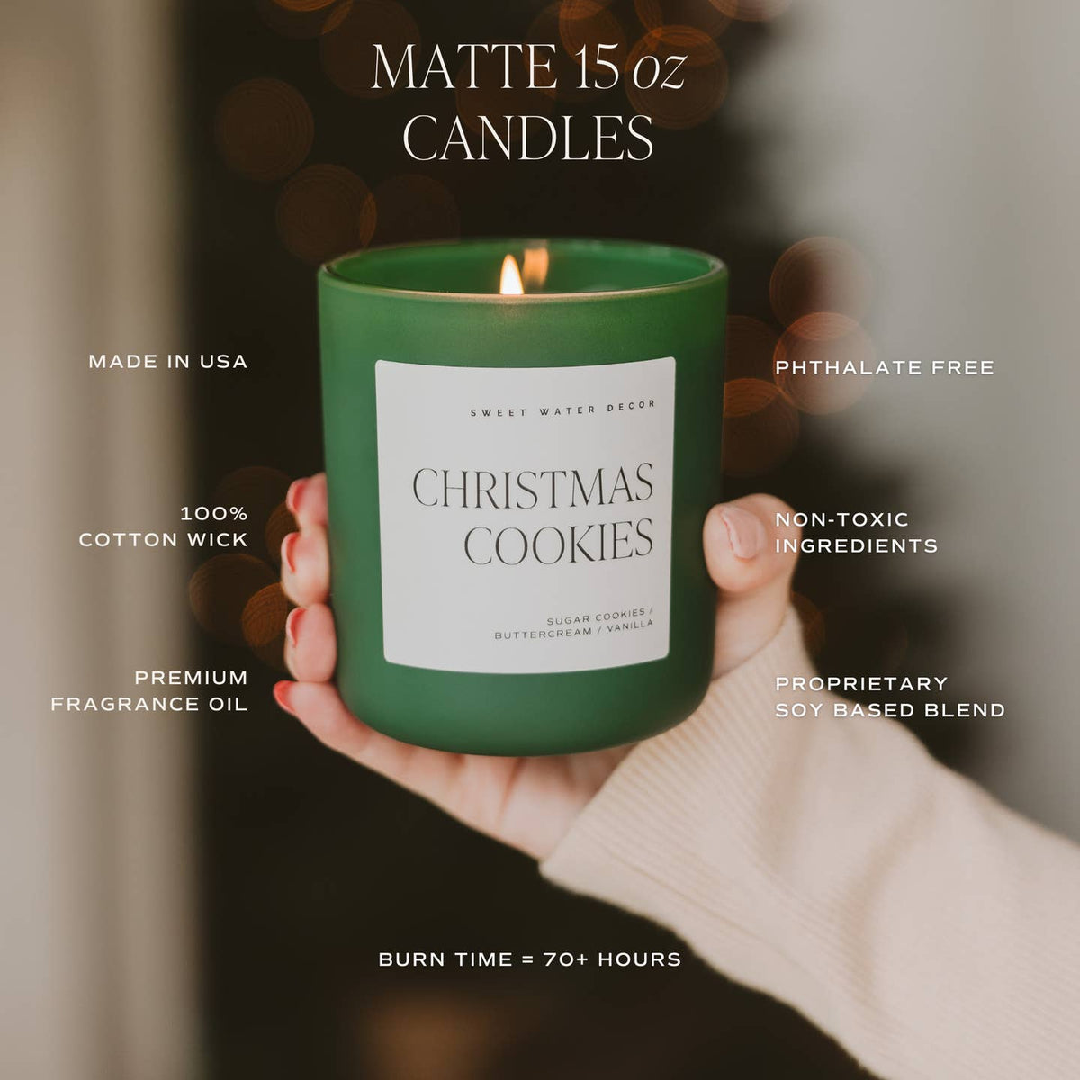Green candle labeled 'Christmas Cookies' held by a hand with blurred background