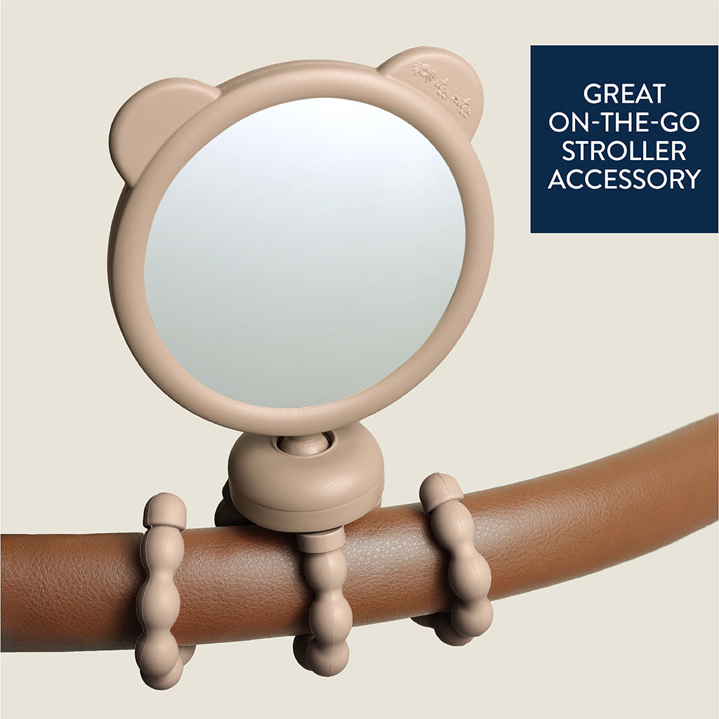 Beige mirror with bear ears attached to a brown handle on a beige background