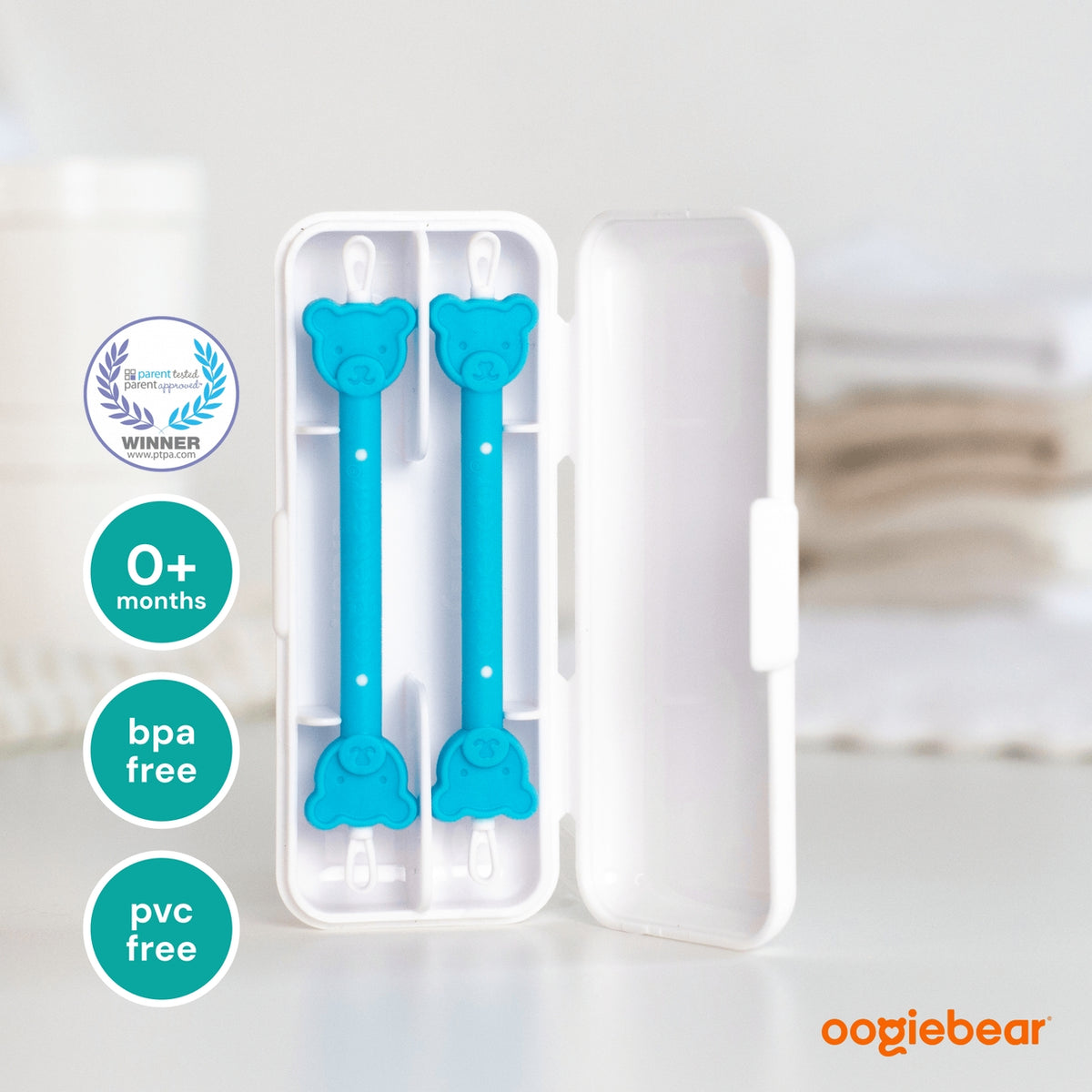 Blue baby utensils in a white case with 'oogiebear' branding on a light background