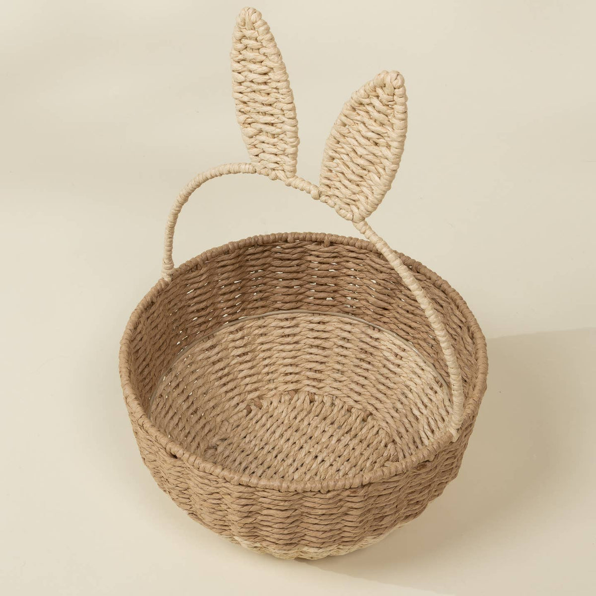 Woven basket with bunny ears on a beige background