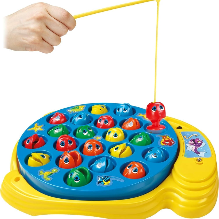 A hand holding a fishing rod over a yellow Let's Go Fishin' game board filled with colorful toy fish.