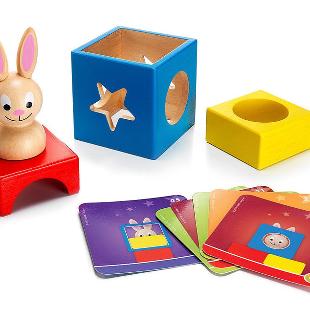 Colorful educational toys including a rabbit figure, shape sorter, and flashcards on a white background
