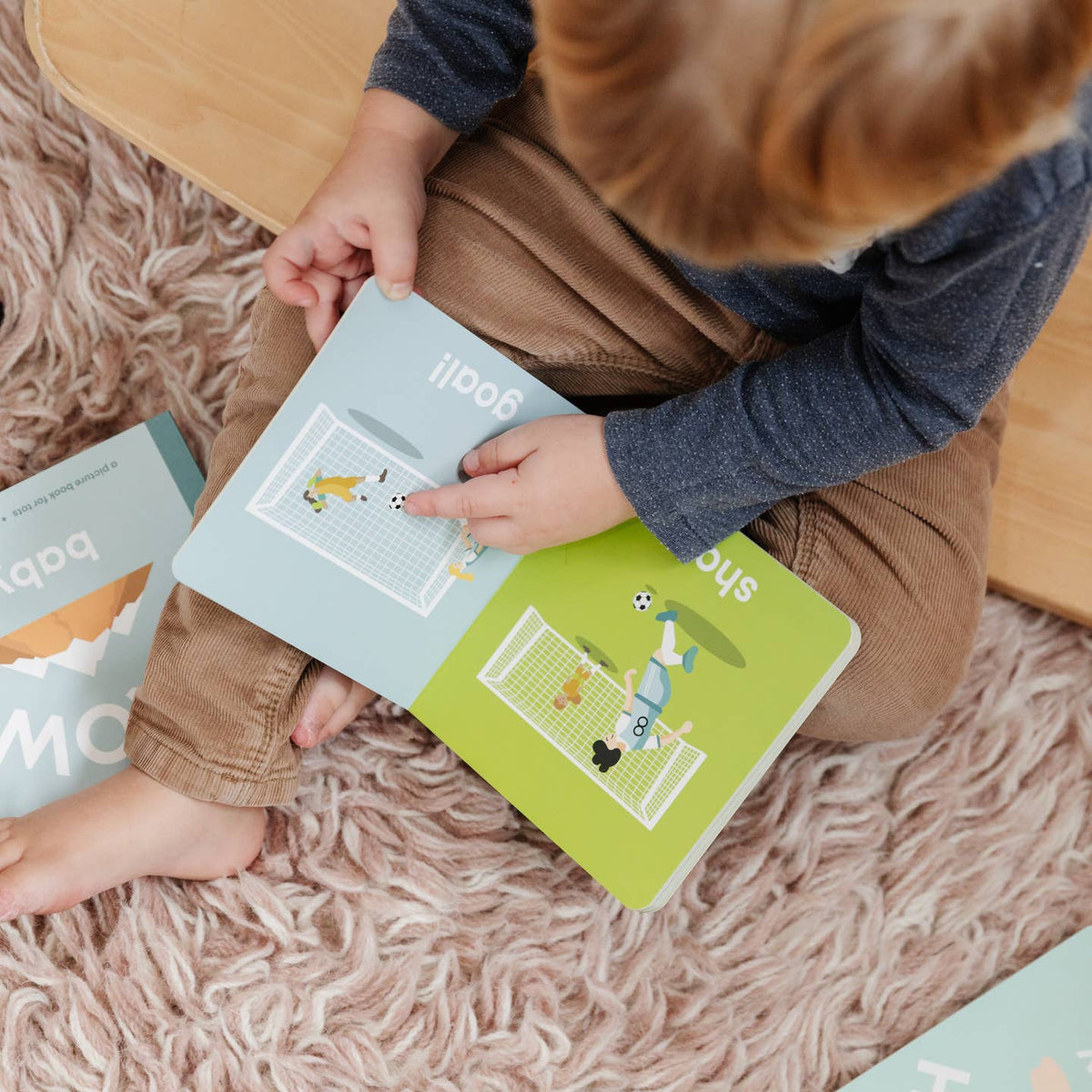 Child reading a book on a fluffy carpet