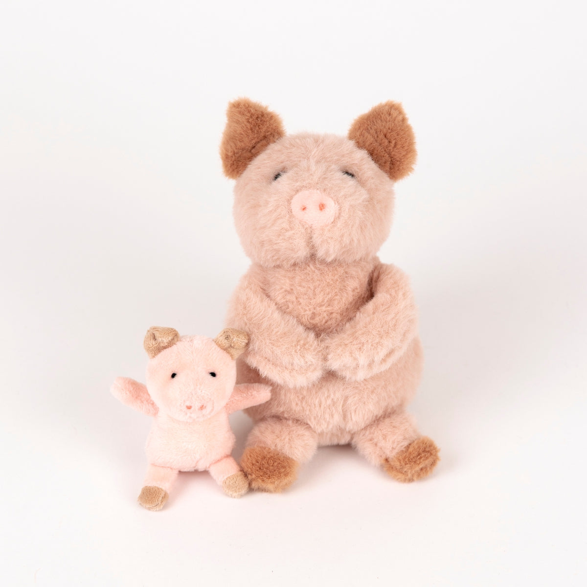 Two plush pig toys on a white background