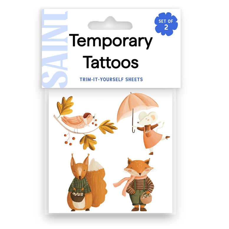 Saint Temporary Tattoos set of 2 temporary tattoo sheets featuring autumn-themed designs including a bird, mouse under an umbrella, squirrel, and fox, in retail packaging.