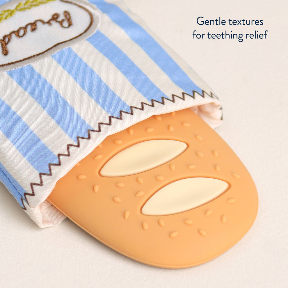 Teething ring with striped fabric cover on a light background