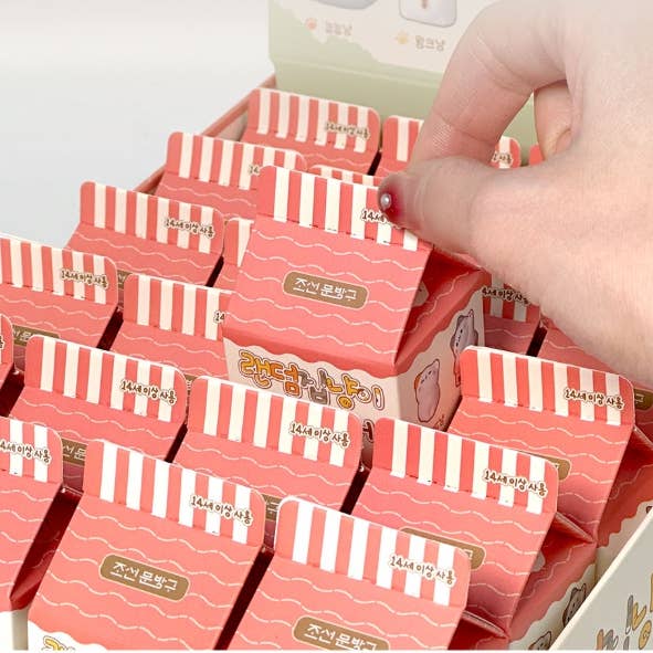 Stack of red and white striped boxes with a hand reaching for one, on a light gray background.
