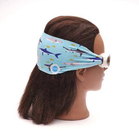 Mannequin head wearing a headband with shark pattern on a white background
