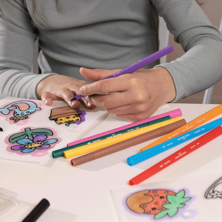 Person coloring with markers on a table with colored pencils and stickers.