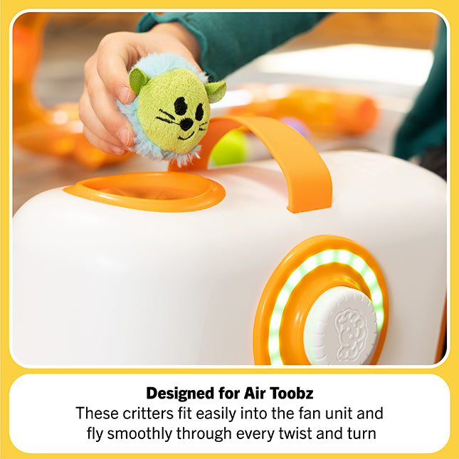 Toy fan with a small green creature attached, designed for Air Toobz, held by a hand.