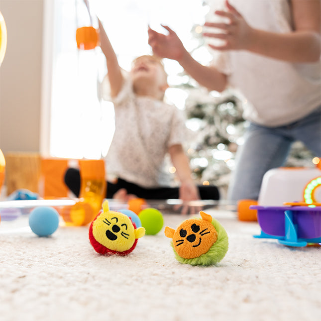 Children playing with colorful toys on a carpeted floor.