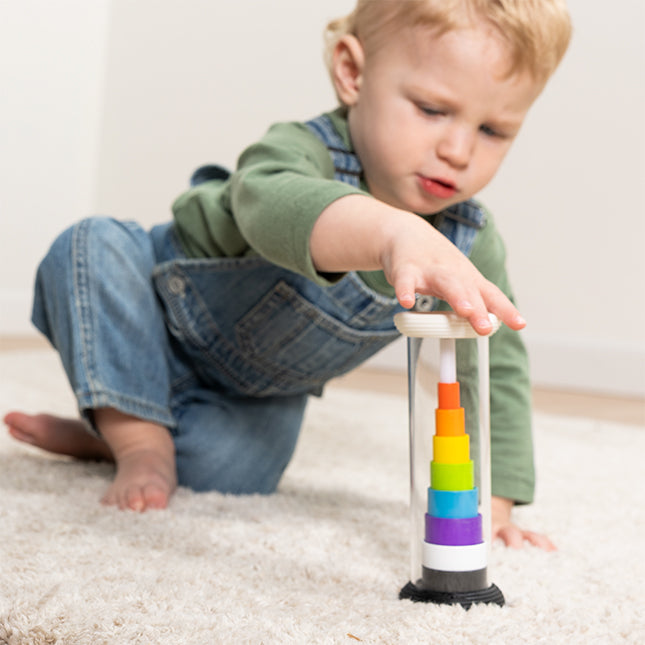 Child playing with a colorful toy on a carpeted floor