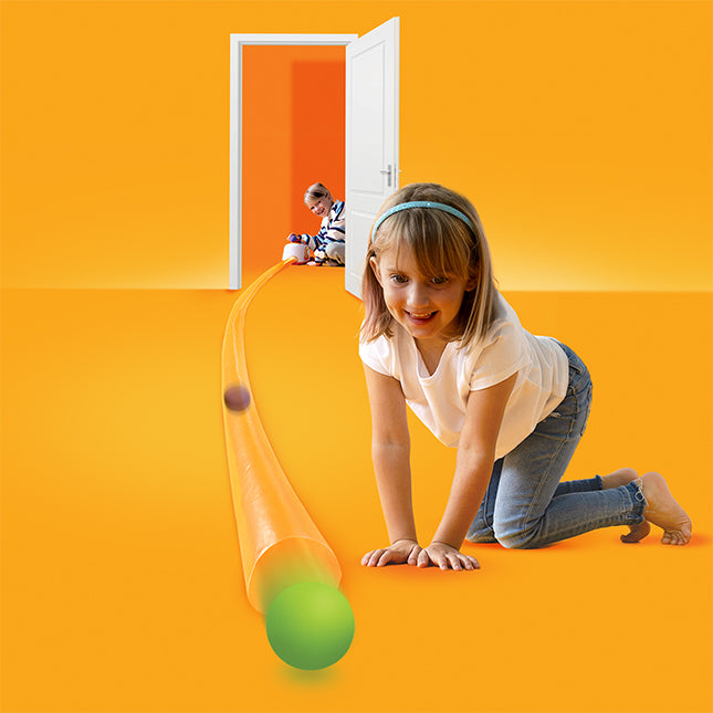 Child playing with a green ball on an orange floor, with a door open to another room.