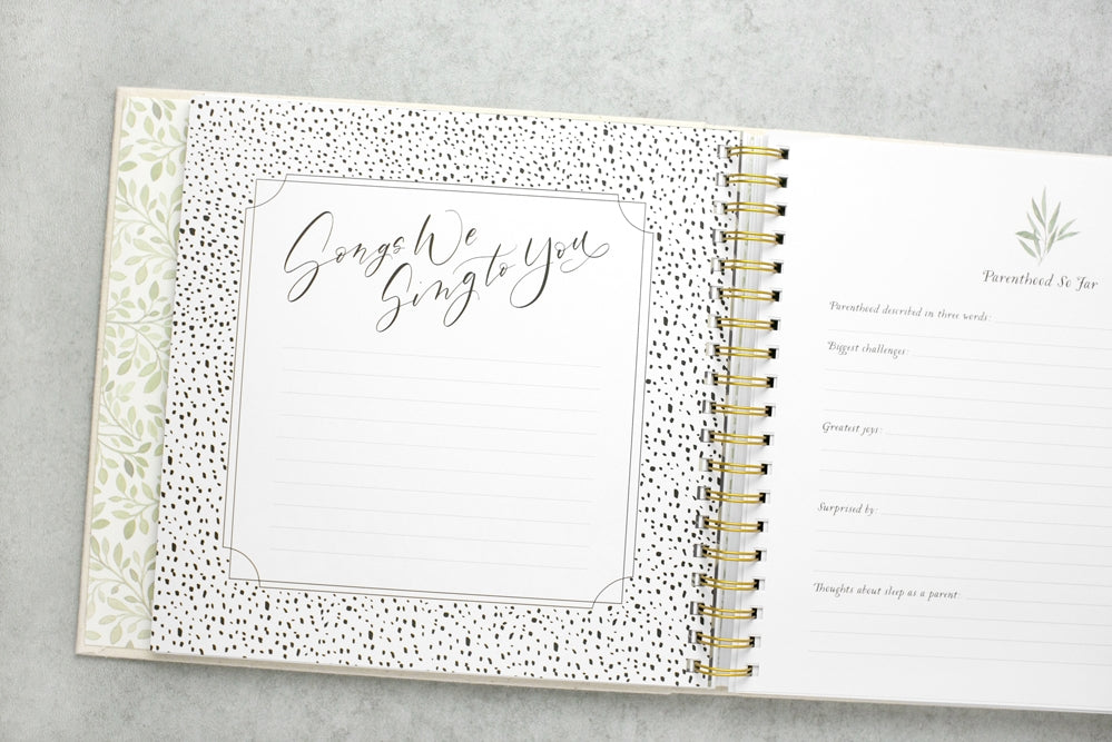 Open spiral-bound planner with decorative cover on a gray surface