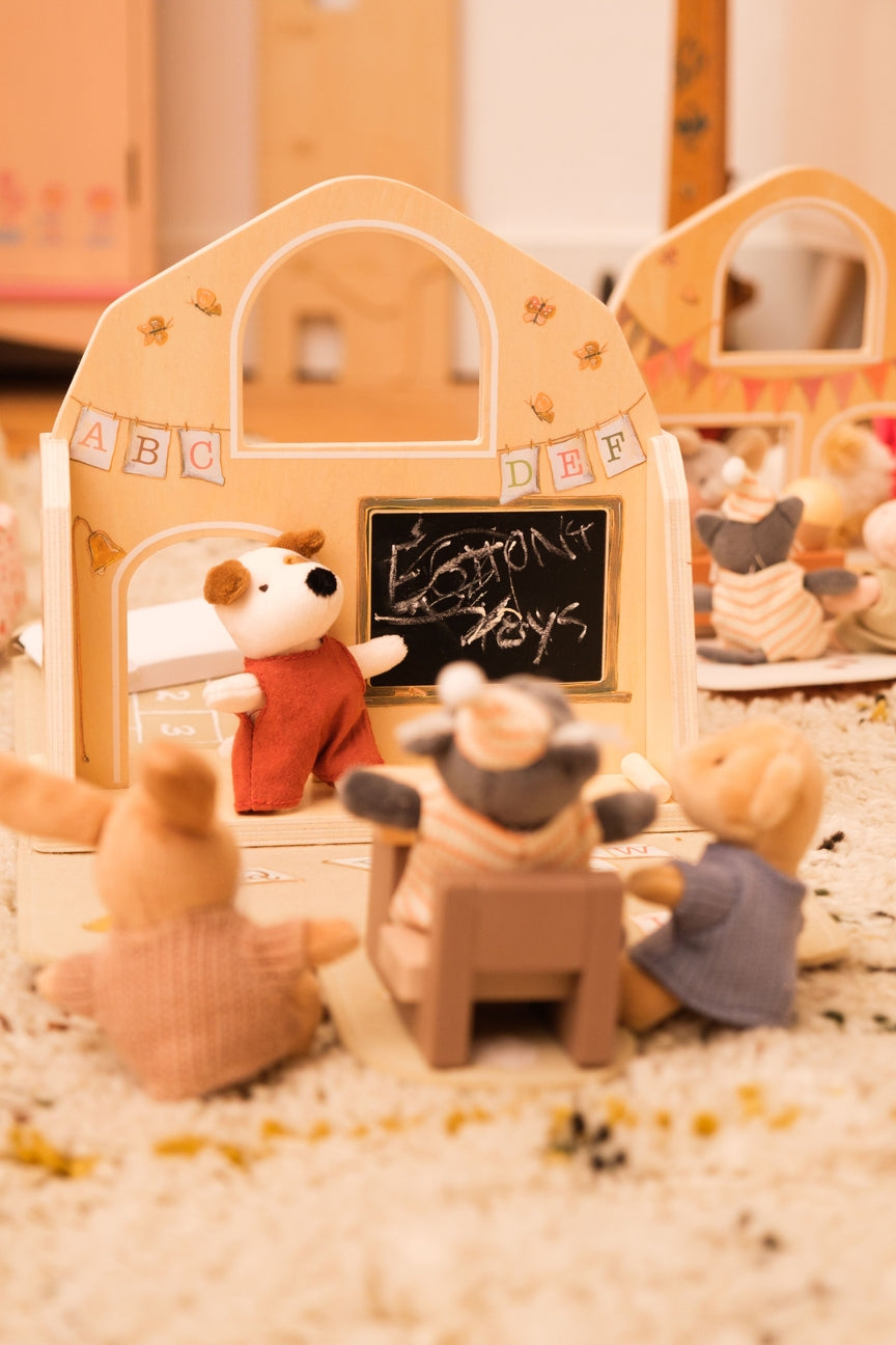 Toy setup with teddy bears in a classroom setting, including a blackboard.